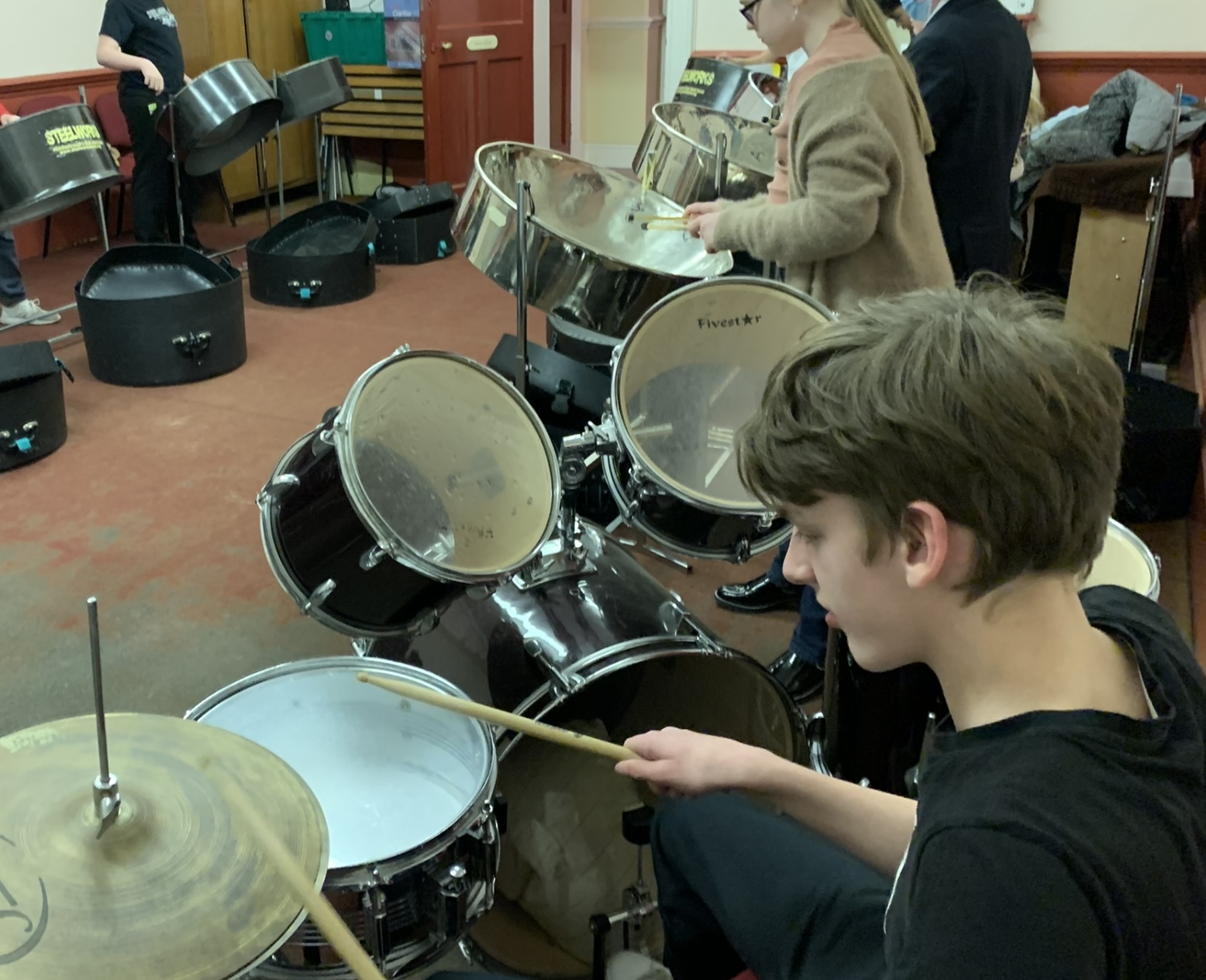 a young boy plays the drums