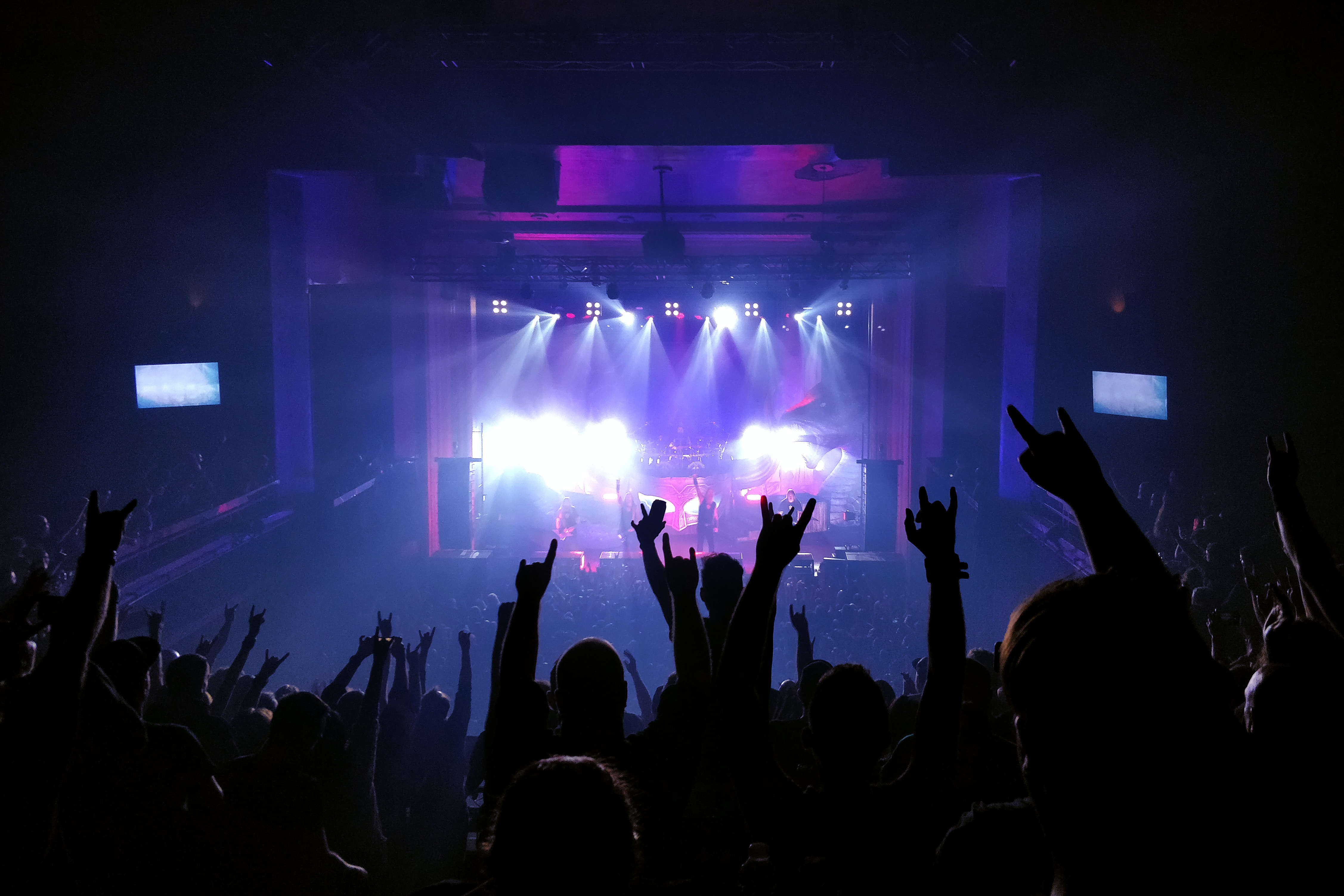 fans raise their hands in the air at a music gig