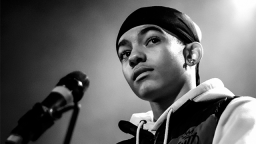 black and white photo of person standing with a microphone in front of them