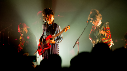 Image of musician Little Simz performing at live on stage with a band. 