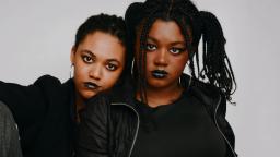 two sisters wearing black lipstick look at the camera