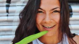 niques smiles and poses with a long green chilli