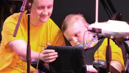 A young musician making music with a facilitator