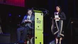 Elizabeth J. Birch on stage holding her award