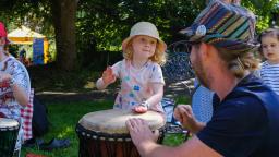 Young child drumming in a park