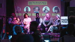 a panel sit on stage in front of an audience