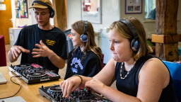 two young girls learn to DJ with an instructor