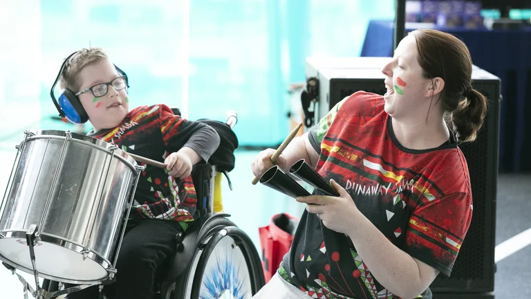 Two people from the project Jack Drum arts playing drums. 