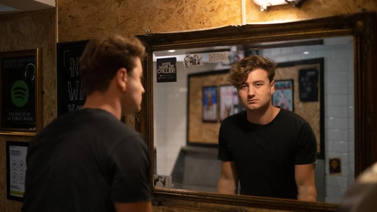 Musician Tom Auton looking at a mirror