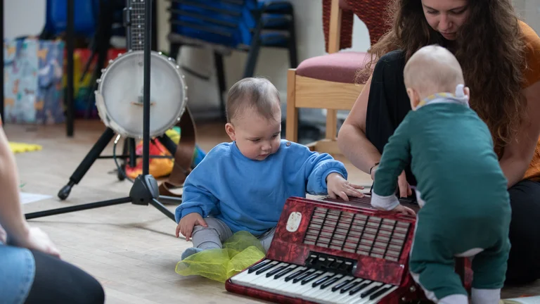 two babies playing musical instruments