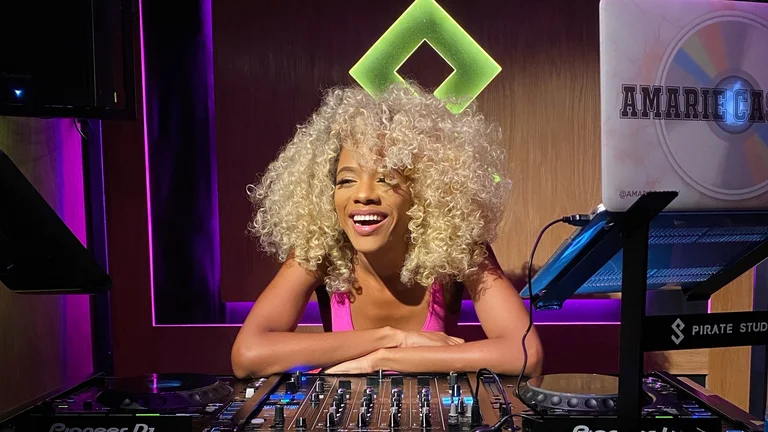 blonde woman laughing and leaning on DJ decks