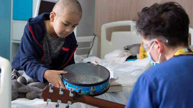 Child in cancer hospital with drums