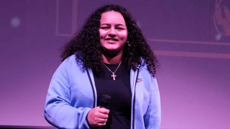 A young woman on stage holding a microphone 