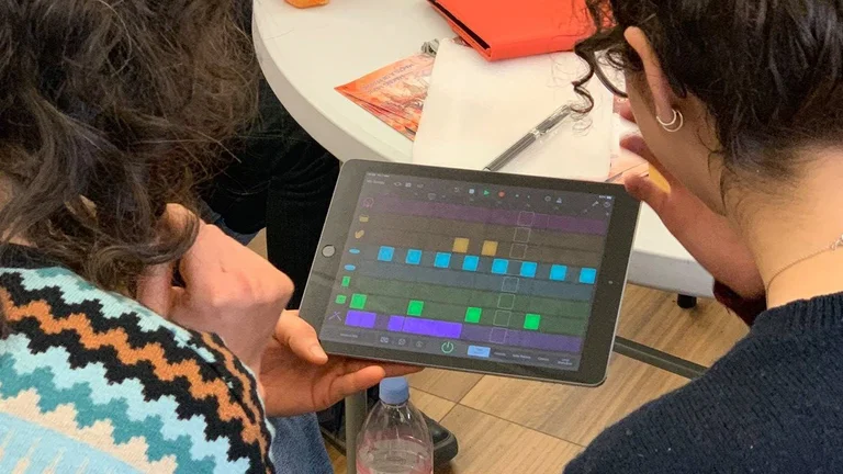 2 people using an iPad to make music