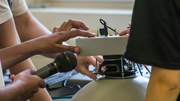 photo of hands holding a microphone and music equipment