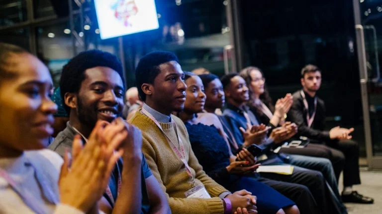 A group of young people watching someone speak