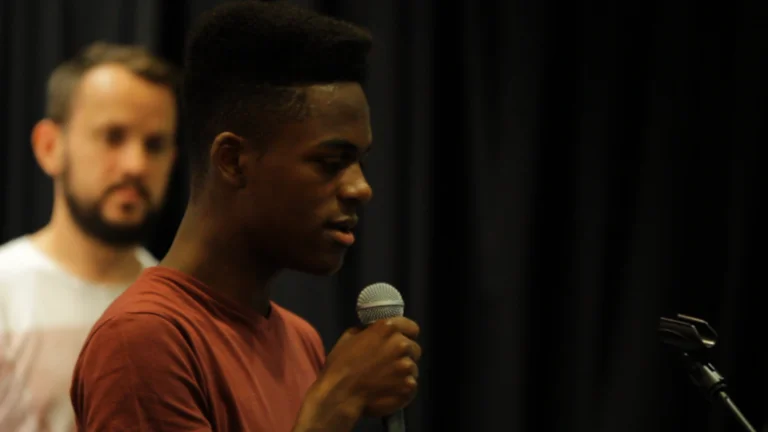 A young man holds a microphone 