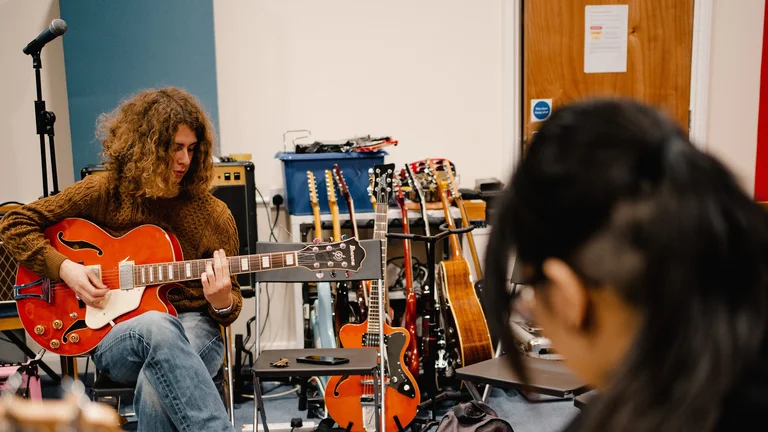 We Make Culture workshop with two young people playing instruments in a classroom