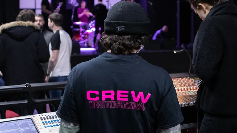 A young person learning to use a sound desk. 