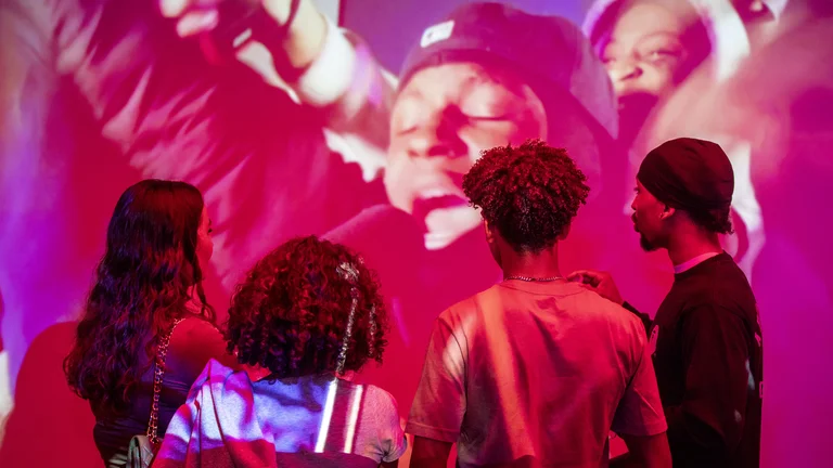 a group of young people watch a projector screen of a music performance