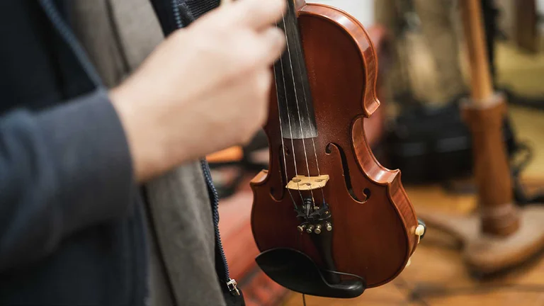 a hand holds a violin