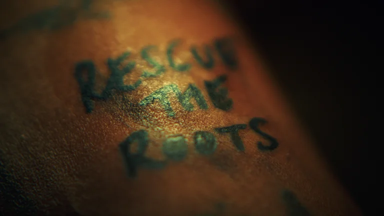 a fresh tattoo saying 'rescue the roots'