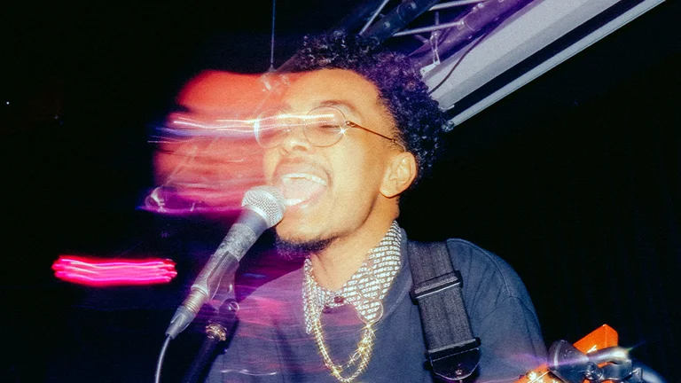 a person sings into a mic, the photo has a blurred effect