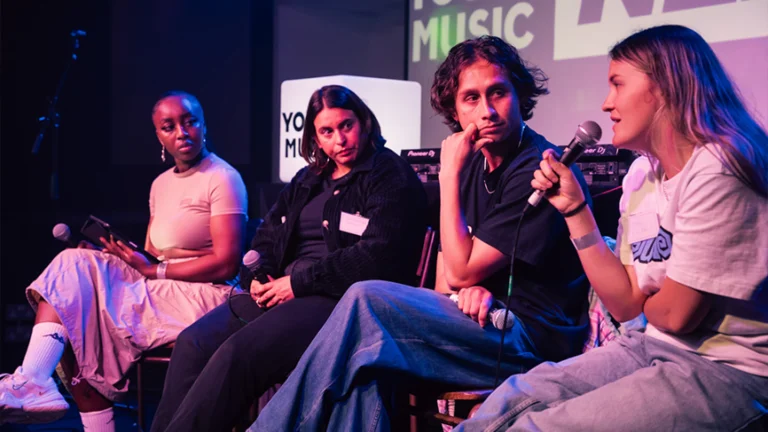 a panel of people sit on stage