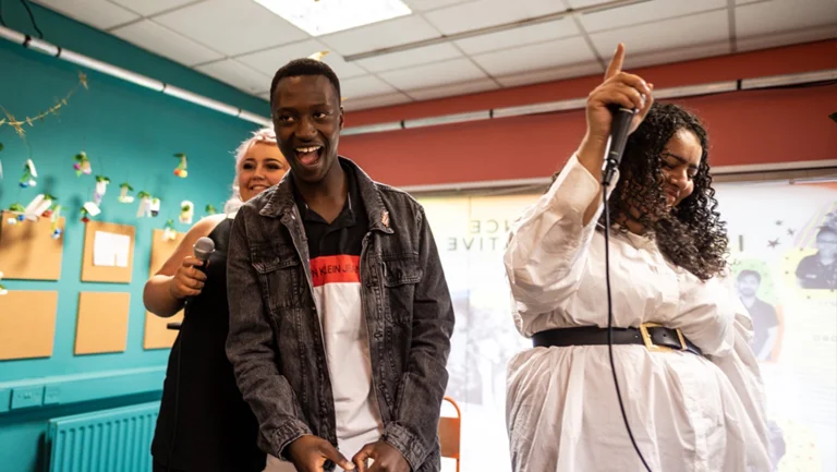 three people in a classroom, dancing