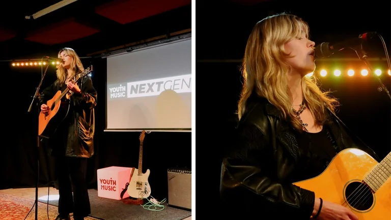 a performer sings and plays guitar on stage