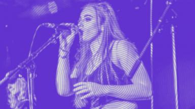 young person performing on stage, purple colour overlayed