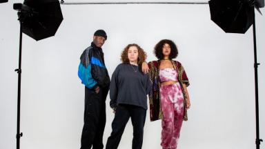 three young people posing for a photo in a studio 