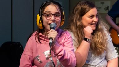 two young people singing into microphones