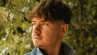 Pat headshot - man looking sideways outside in front of a hedge