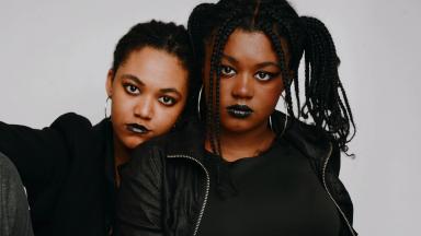 two sisters look at the camera. they are wearing black lipstick