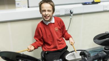 a young boy plays the drums