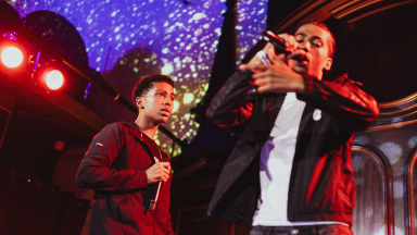 two young men rap on stage together