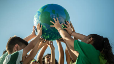 children holding up a globe together