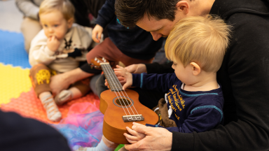 baby with father and a small guitar