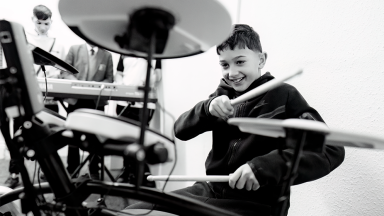 a boy plays the drums enthusiastically 