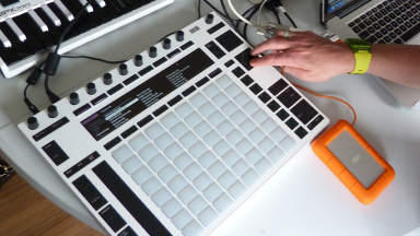 a hand works on an electronic music machine