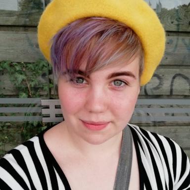 Selfie of Malene Simonsen wearing a yellow hair, a black and white strip top.