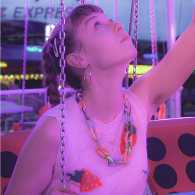 Lily is on a fun-fair ride wearing a sleeveless knitted top