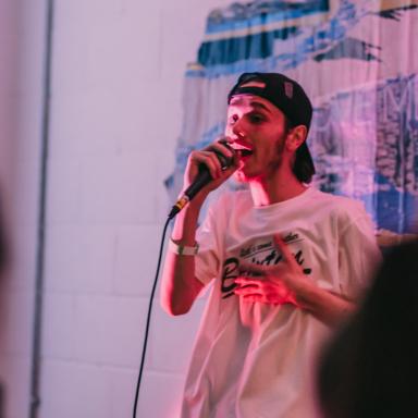lil trubz on the mic wearing a backwards cap