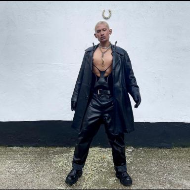 HASZNAT* wearing black leather trousers and coat with bare chest, outside in front of black and white wall