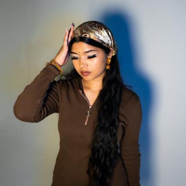 Maharani wearing a brown top, paisley headscarf and white eyeliner