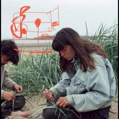 Lene de Montaigu wearing a blue jumper and sitting on the floor with grass in the background