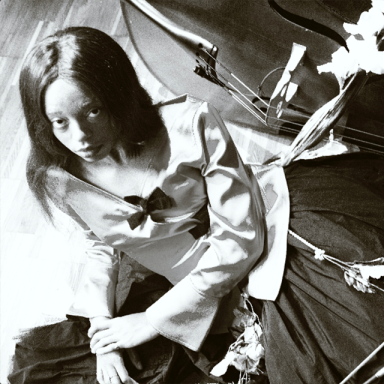 a person lays on the floor next to a double bass. the photo is in black and white