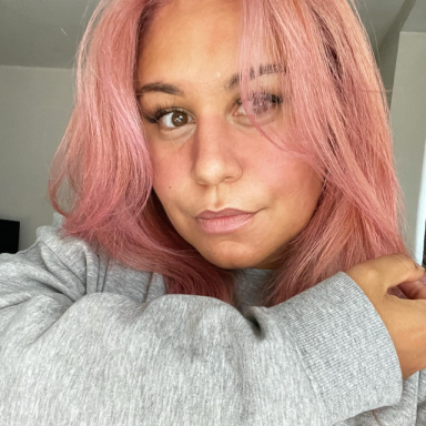 vanessa threadgold wears a grey sweater and has pink hair