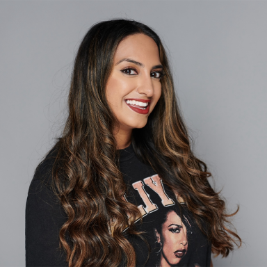 a woman with long brown hair and red lipstick smiles